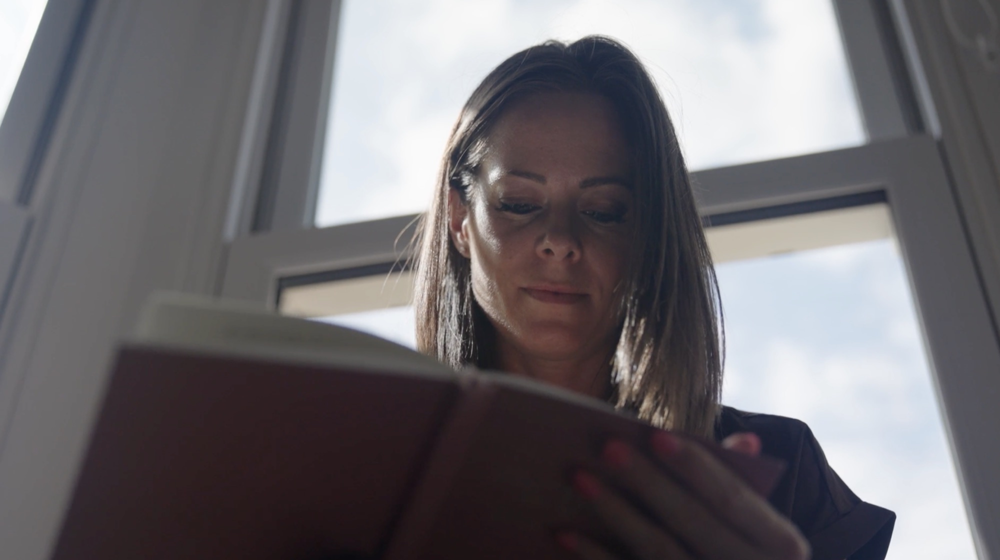 Zoe reading through planning documents by a window